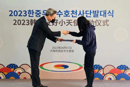 The South Korean Ambassador to China Chung Jae-Ho (left) shakes hands with one little angel. Photo: Courtesy of the Embassy of South Korea in China