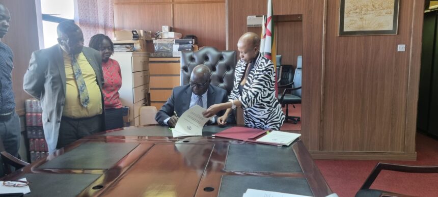 Honourable J. G. Moyo, Minister of Local Government, Public Works, and National Housing and Minister responsible Disaster Risk Management signing the Memorandum of Agreement for the establishment of the SHOC
