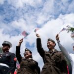 New US citizens wave flags after being sworn in at a naturalization ceremony in Mount Vernon, Virginia, on Tuesday. Stefani Reynolds/AFP/Getty Images