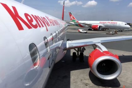 A fleet of Kenya Airways aircraft lined up for takeoff.