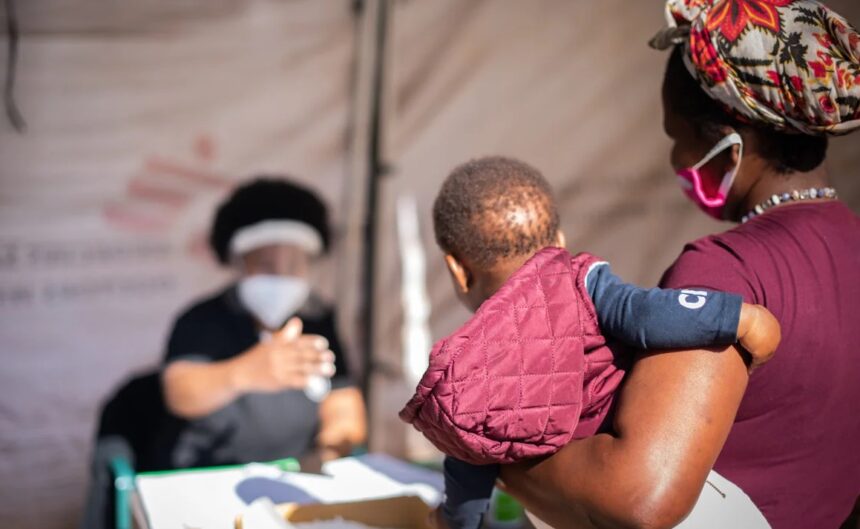 Doctors Without Borders (MSF) official attending to a mother and child.