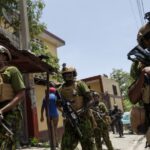 Haitian National police SWAT unit and Kenyan Police walk trough a steep hill to board an armoured vehicle after one of the vehicles broke down on a steep hill while patrolling through a neighborhood, after the arrival of the first contingent of Kenyan police as part of a peacekeeping mission, in Port-au-Prince, Haiti June 28, 2024. REUTERS/Ricardo Arduengo