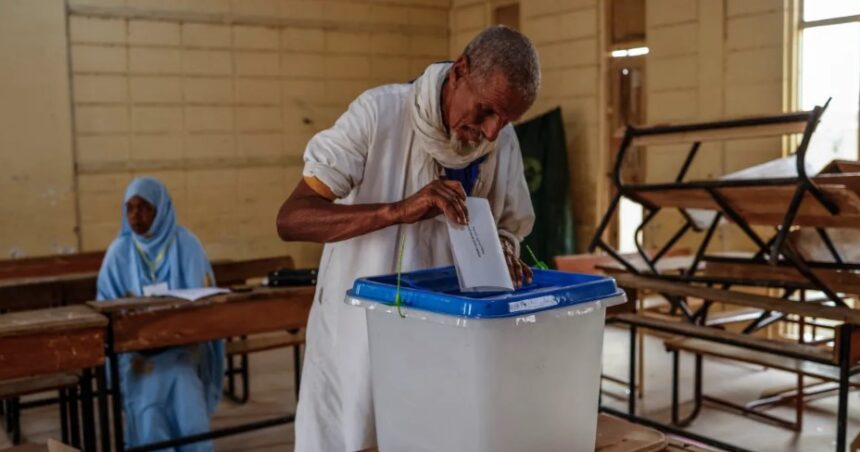 A voter casts his ballot at a polling station in the capital Nouakchott [John Wessels/AFP]