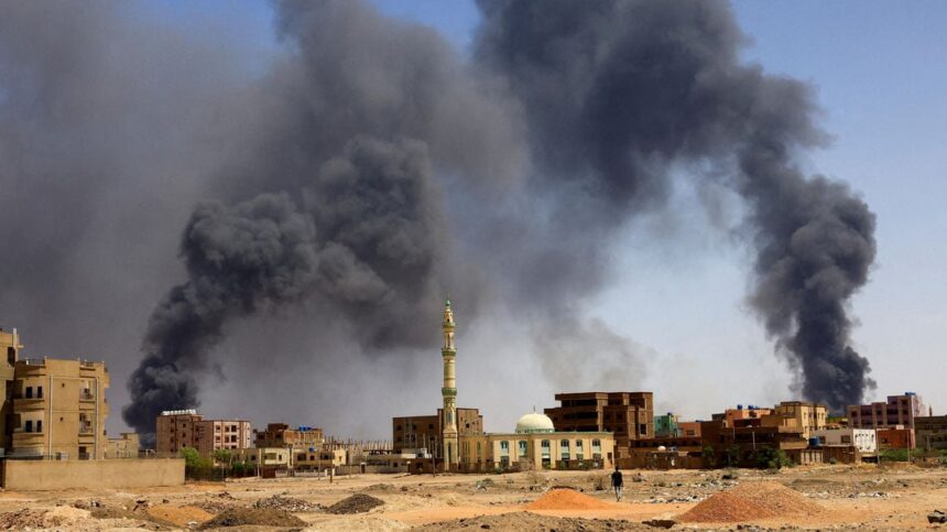 A man walks as smoke rises over buildings following air strikes during clashes between the paramilitary Rapid Support Forces and the Sudanese army in Khartoum North on May 1, 2023. File | Reuters