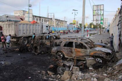 People gather near the wreckages of vehicles destroyed at the scene of an explosion outside a restaurant where patrons were watching the final of the Euro 2024 football tournament on TV, in Bondhere district of Mogadishu, Somalia July 15, 2024. REUTERS/Feisal Omar