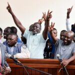 Ugandan opposition supporters gesture in the dock where they were charged with terrorism-related offences, after they were deported from neighbouring Kenya, where they had traveled to attend a training course in Kisumu, at the Nakawa Chief Magistrates court in Kampala, Uganda July 29, 2024. REUTERS/Abubaker Lubowa