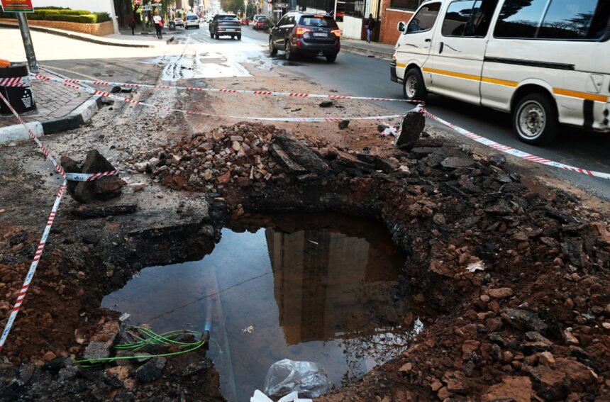 Traffic navigates a hole on a road in Johannesburg.Photographer: Leon Sadiki/Bloomberg