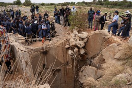 Community members watch as Senzo Mchunu, South African police minister, inspects outside the mineshaft where it is estimated that hundreds of illegal miners are believed to be hiding underground, after police cut off food and water as part of police operations against illegal miners, in Stilfontein, South Africa, November 15, 2024. REUTERS/Ihsaan Haffejee