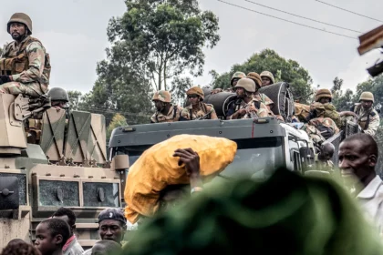 Soldiers from the SADC Mission in DRC drive past people fleeing a resumption of fighting, East of Goma, North Kivu, Democratic Republic of the Congo, on 7 February 2024. (Photo: EPA-EFE / Moses Kasereka)