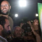 Muammar Gaddafi's son Saif al-Islam (top left) gestures to troops loyal to his father in Tripoli in August 2011, months before the late dictator's fall. © Imed Lamloum, AP file photo
