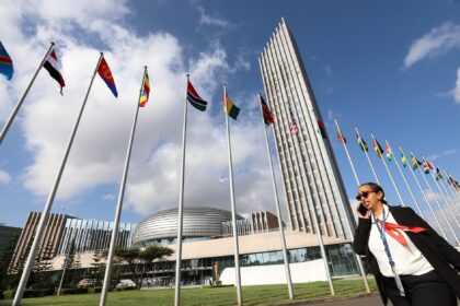 A delegate walks past African Union (AU) member states national flags during the opening of the 37th Ordinary Session of the Assembly of the African Union at the African Union Headquarters, in Addis Ababa, Ethiopia February 17, 2024. REUTERS/Stringer/File Photo