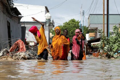 A Somali family wades through flood waters, as they flee after overnight rains destroyed their home, in Wadajir district of Mogadishu, Somalia May 10, 2025. REUTERS/Feisal Omar
