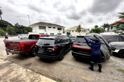 Officials from Ghana’s Economic and Organized Crime Office uncover the dozens of stolen vehicles they’ve seized over just a few weeks. Nearly every vehicle was stolen from Canada before being shipped to Ghana and put up for sale at market price. (David Common/CBC)